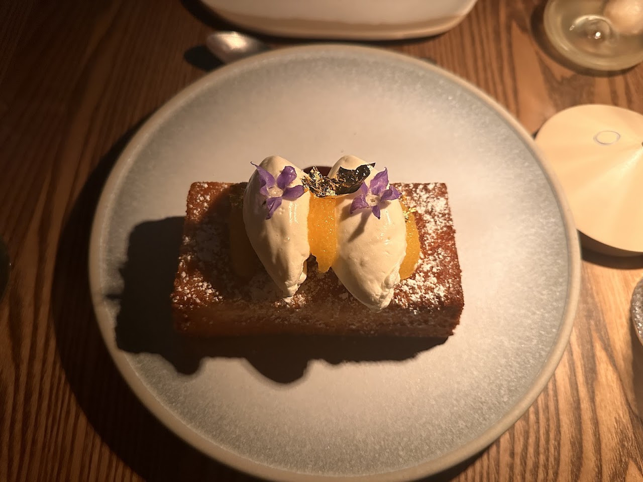 Olive oil cake plated under warm table light